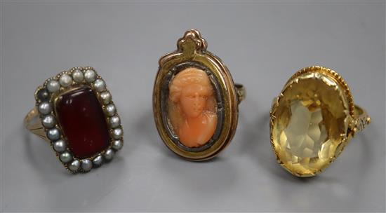 Three assorted yellow metal gem set rings including a carved coral cameo.